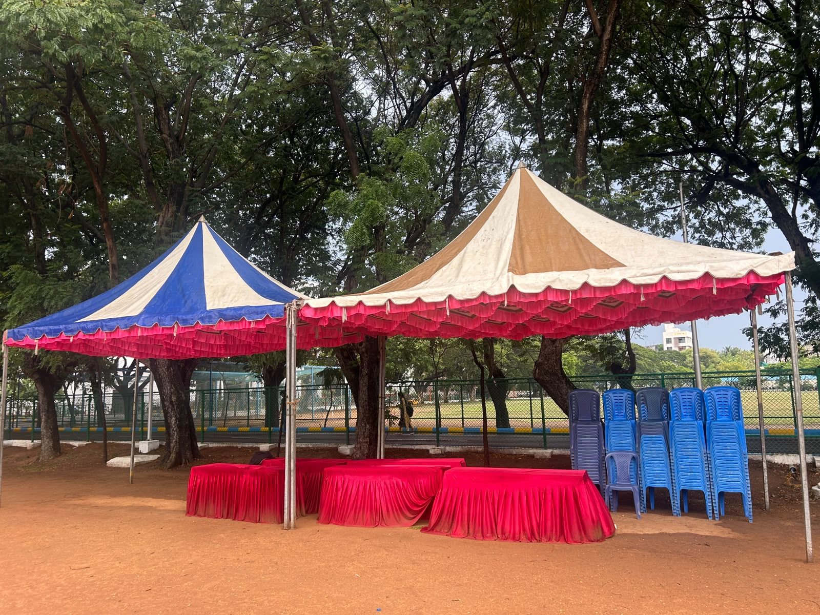 Shaded tents and team seating set up for a corporate cricket event at Loyola College Ground, Chennai